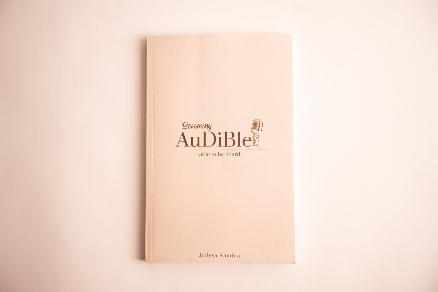 Beige book with 'Audiible' logo and text on a beige background