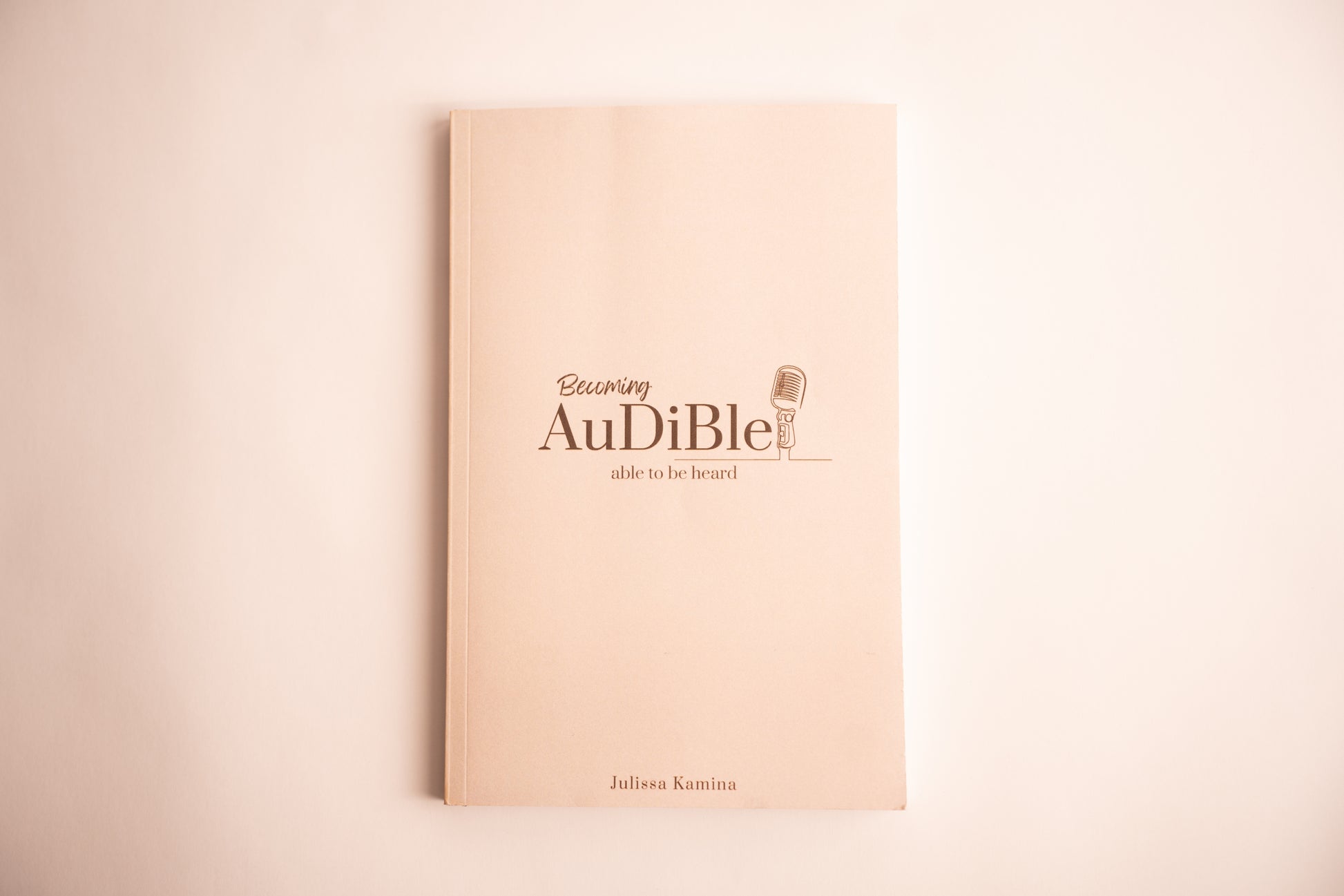 Beige book with 'Audiible' logo and text on a beige background