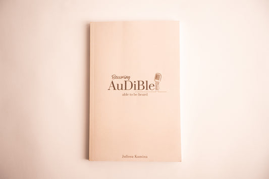 Beige book with 'Audiible' logo and text on a beige background